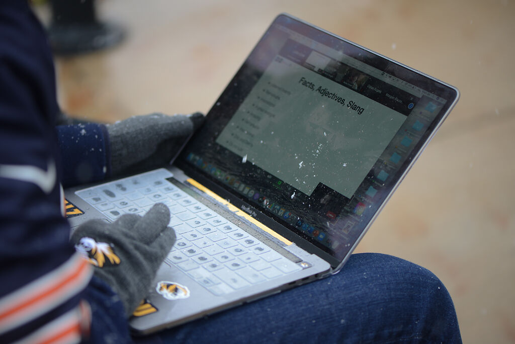 Justin Craft participates in a Zoom lecture while snow falls on his laptop